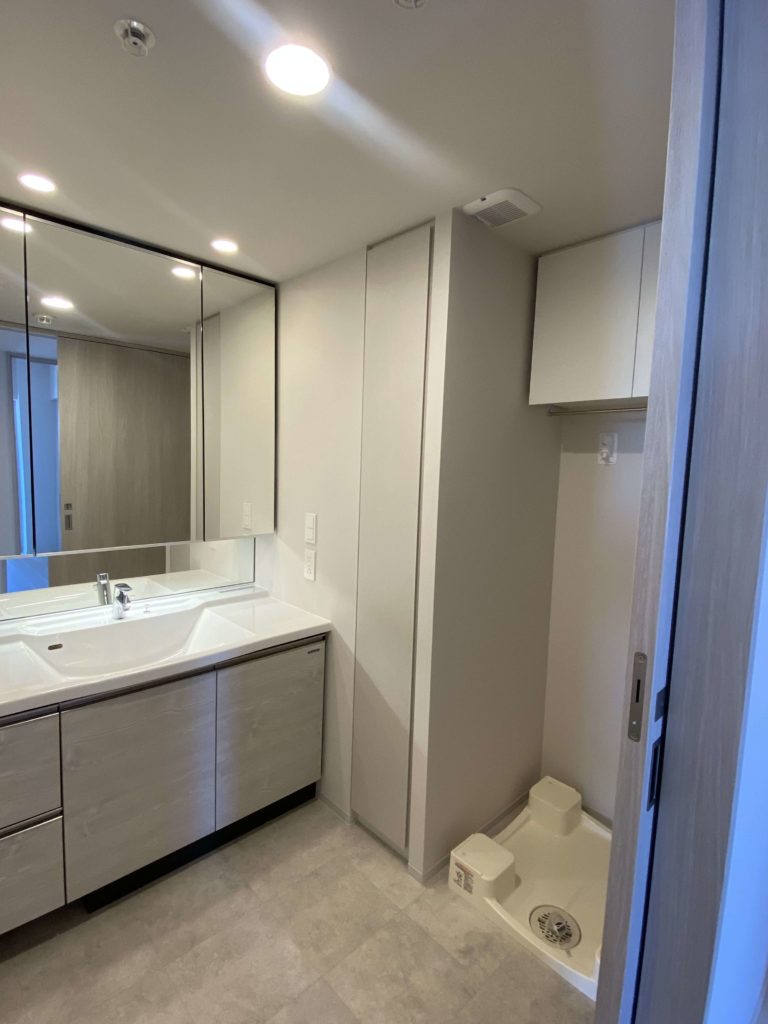 清潔感のある独立洗面台と収納付きミラー